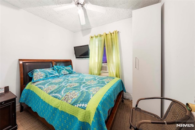 bedroom with ceiling fan and a textured ceiling