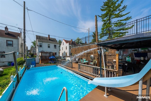 view of pool featuring a wooden deck and a water slide