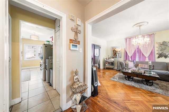 hallway featuring a chandelier and light tile patterned floors