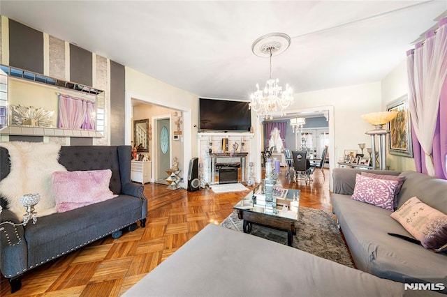 living room featuring a chandelier and parquet flooring