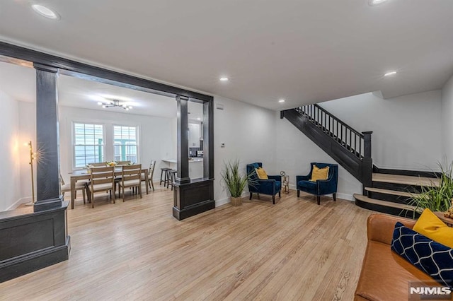 living room featuring light hardwood / wood-style floors and ornate columns