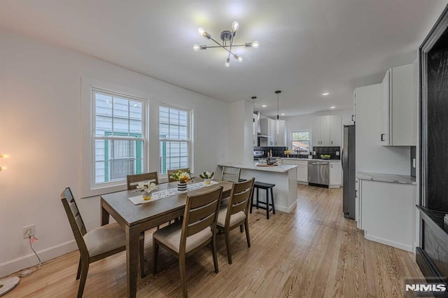 dining area featuring light hardwood / wood-style floors and a notable chandelier