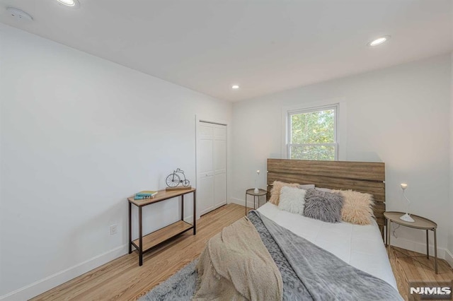 bedroom with a closet and light hardwood / wood-style floors