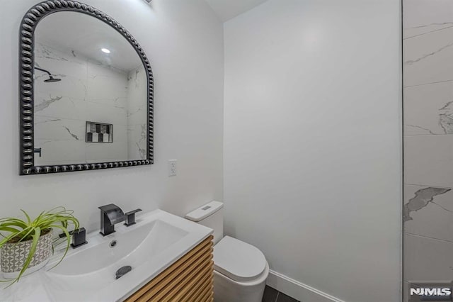 bathroom with vanity, toilet, and a shower