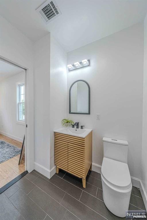 bathroom featuring tile patterned floors, vanity, and toilet