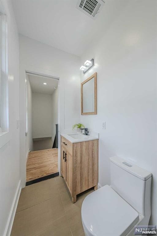 bathroom featuring tile patterned floors, vanity, and toilet