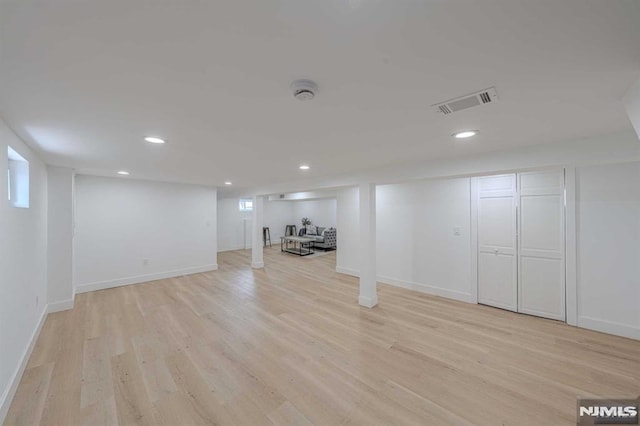 basement with light hardwood / wood-style flooring