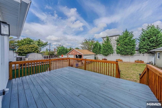 wooden terrace featuring a lawn and a shed