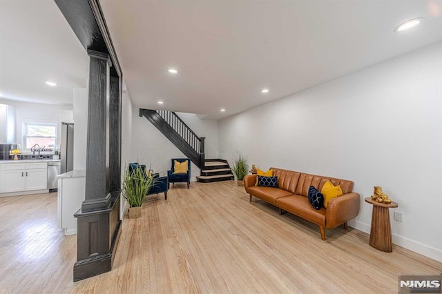 living room featuring sink and light hardwood / wood-style flooring