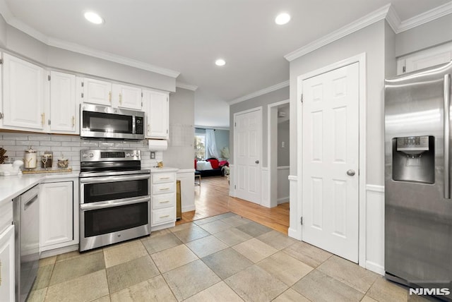 kitchen featuring decorative backsplash, white cabinetry, ornamental molding, and stainless steel appliances