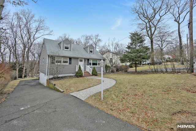 cape cod home featuring a front yard