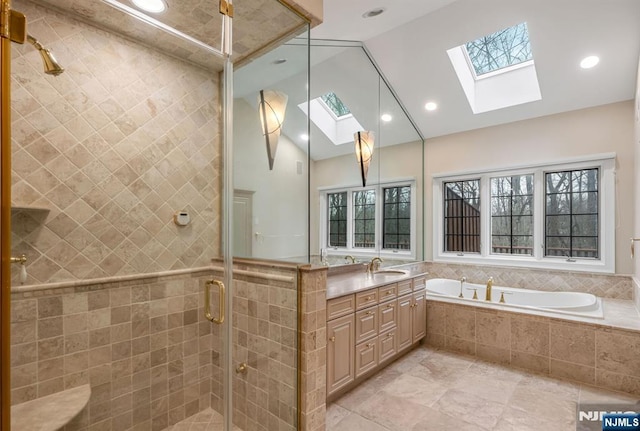 full bath featuring high vaulted ceiling, a skylight, vanity, a shower stall, and a bath