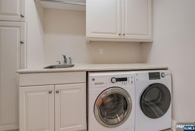 washroom featuring a sink, cabinet space, and washer and dryer