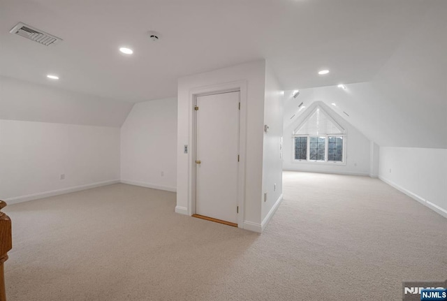 additional living space featuring carpet floors, visible vents, vaulted ceiling, and baseboards