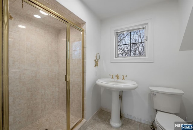 bathroom with a stall shower, tile patterned flooring, and toilet