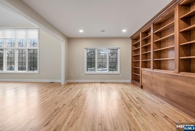 empty room featuring light wood-style flooring, baseboards, built in features, and recessed lighting