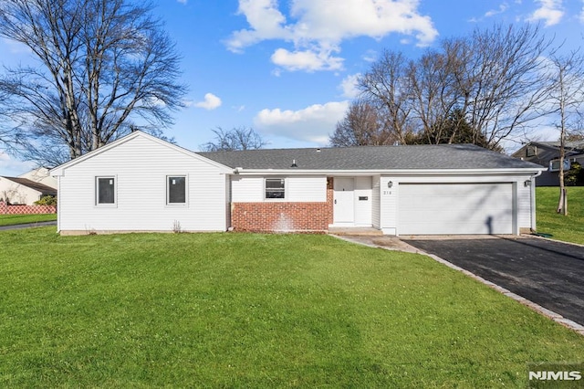 ranch-style house featuring a garage and a front lawn