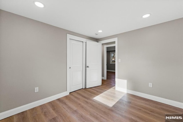 unfurnished bedroom featuring light wood-type flooring and a closet