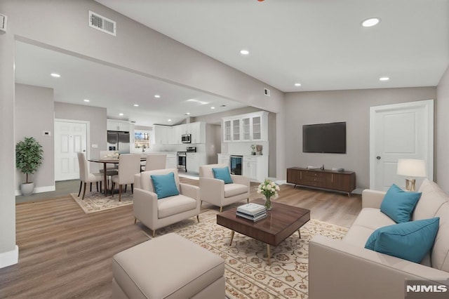 living room with light hardwood / wood-style floors and lofted ceiling