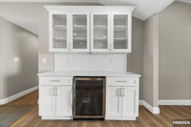 bar with white cabinets, dark hardwood / wood-style floors, backsplash, and wine cooler