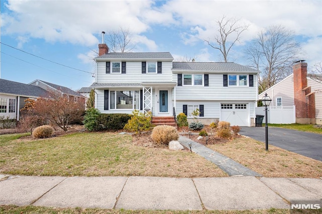 view of front of home with a front lawn and a garage