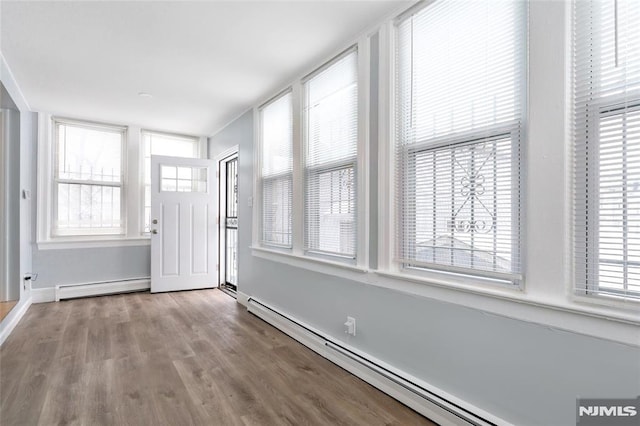 unfurnished sunroom featuring baseboard heating and a wealth of natural light