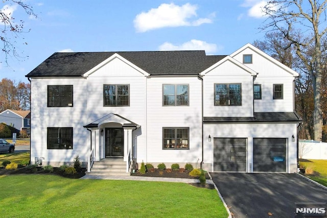 modern farmhouse featuring a front lawn and a garage