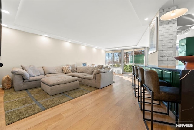 living room with light hardwood / wood-style flooring and a wall of windows