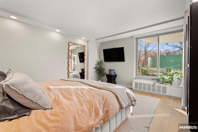 bedroom with light hardwood / wood-style flooring and radiator