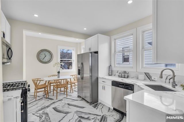 kitchen featuring white cabinets, light stone counters, sink, and stainless steel appliances