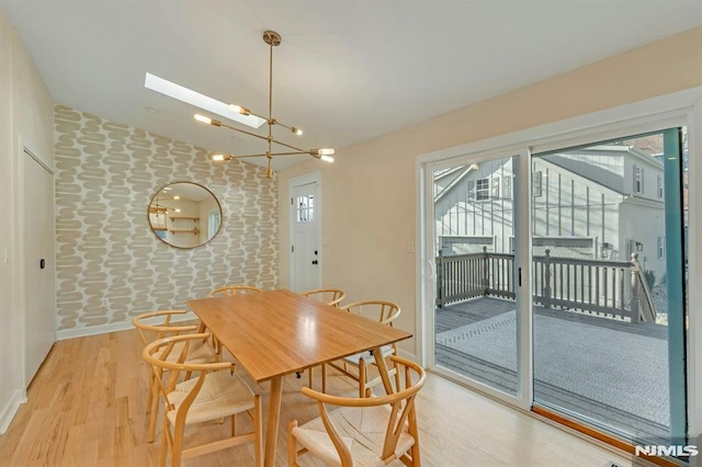 dining area featuring light wood-type flooring and an inviting chandelier