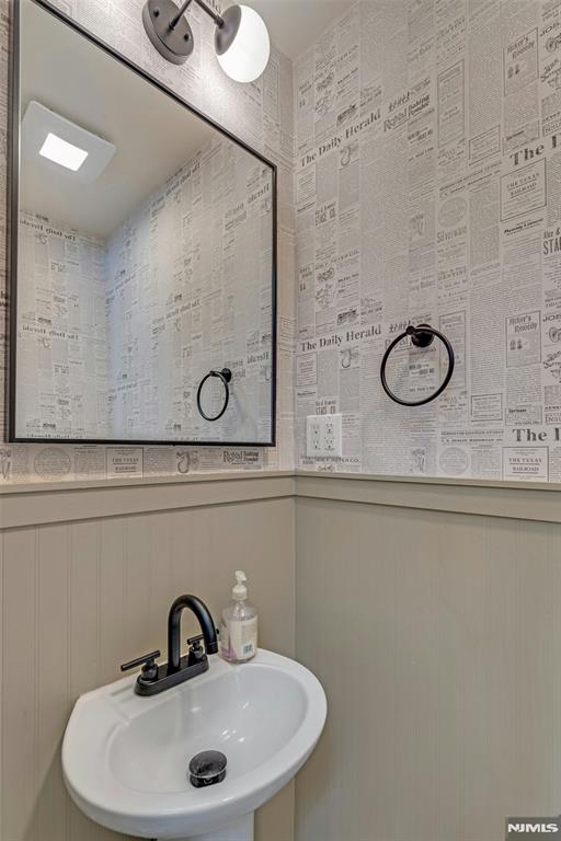 bathroom with sink and wood walls