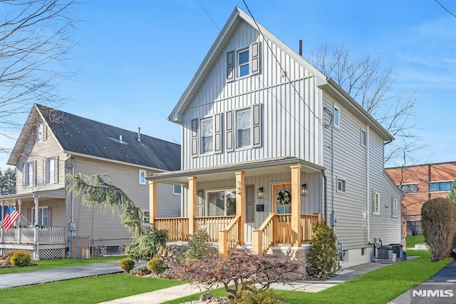 view of front of home with a porch, central AC unit, and a front yard