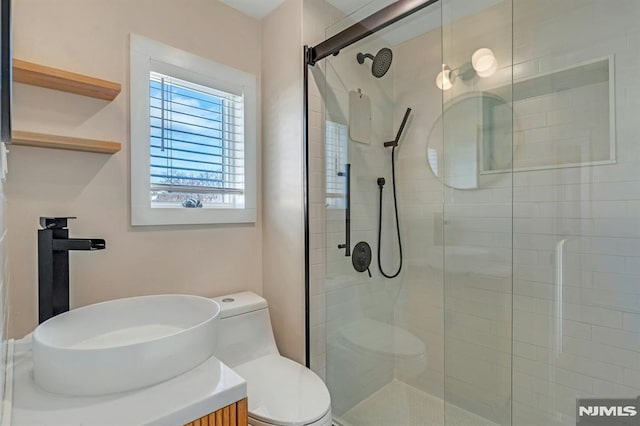 bathroom featuring toilet, walk in shower, and vanity