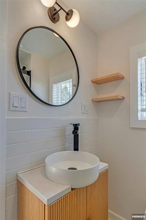 bathroom with sink, a healthy amount of sunlight, and backsplash