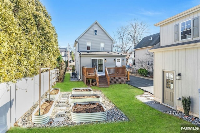 rear view of property featuring a yard and a wooden deck