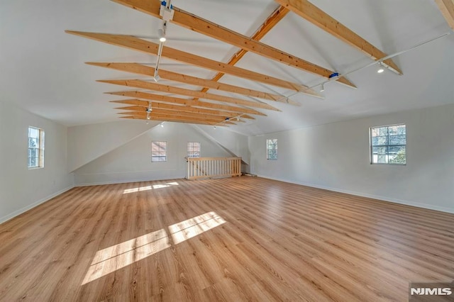 additional living space with a wealth of natural light, light wood-type flooring, high vaulted ceiling, and beamed ceiling