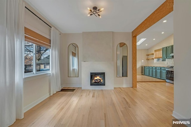 unfurnished living room with lofted ceiling and light hardwood / wood-style floors