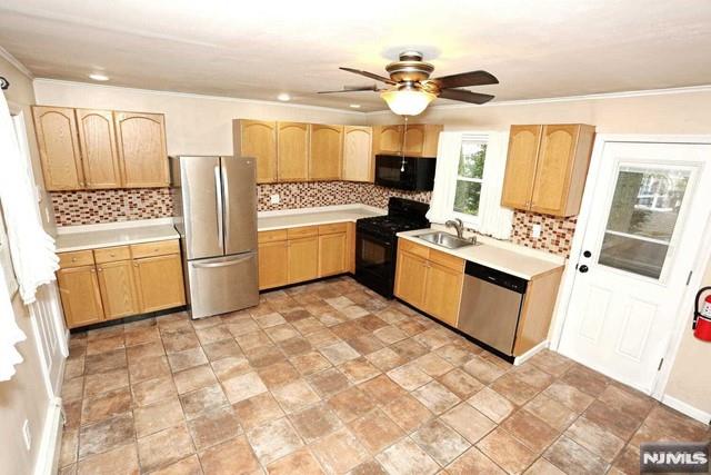 kitchen featuring ceiling fan, sink, light brown cabinets, backsplash, and black appliances