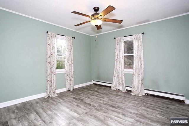 spare room featuring hardwood / wood-style floors, ceiling fan, and crown molding