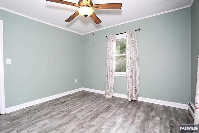 spare room featuring hardwood / wood-style floors, a baseboard heating unit, ceiling fan, and ornamental molding