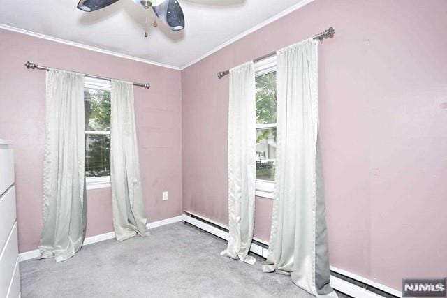 carpeted spare room with ceiling fan and plenty of natural light