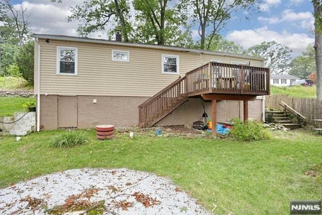 rear view of house featuring a yard and a wooden deck