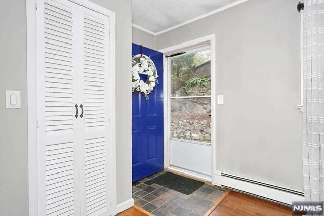 entrance foyer with crown molding and a baseboard heating unit