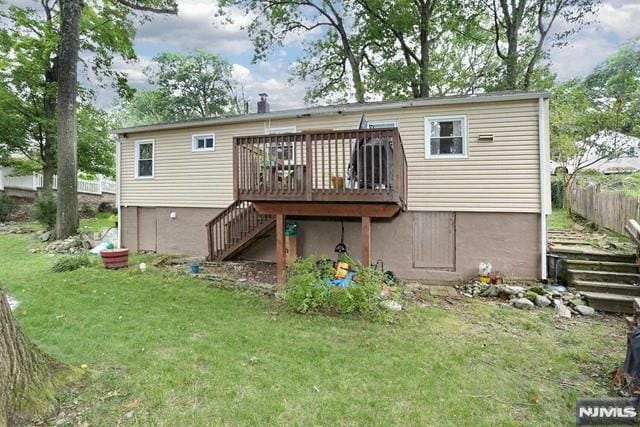 rear view of house with a wooden deck and a yard