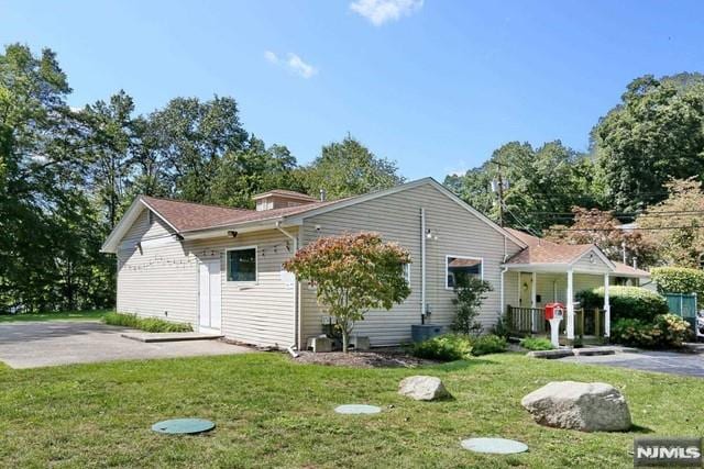 back of property with covered porch and a yard