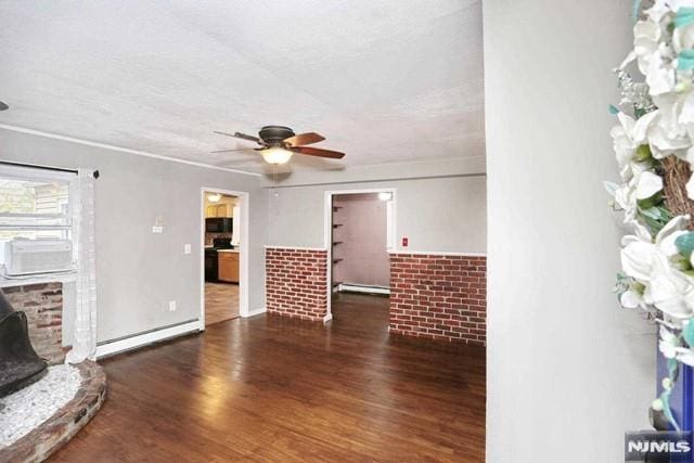 unfurnished living room with brick wall, dark hardwood / wood-style floors, and a baseboard heating unit