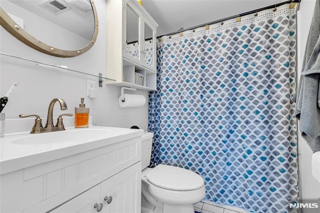 bathroom featuring toilet, vanity, tile patterned floors, and walk in shower