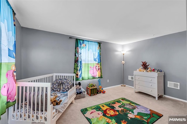 bedroom featuring carpet flooring and a nursery area