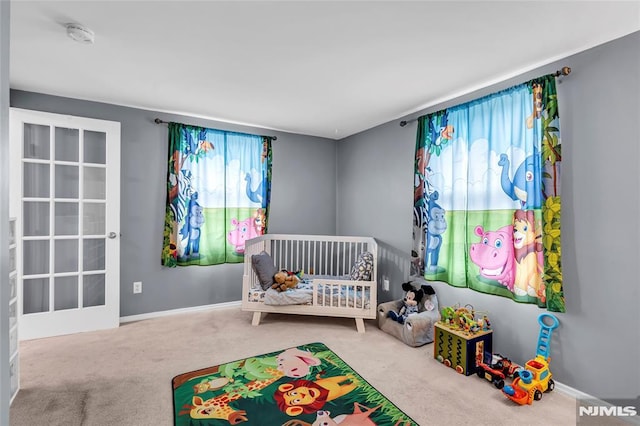 carpeted bedroom with a nursery area